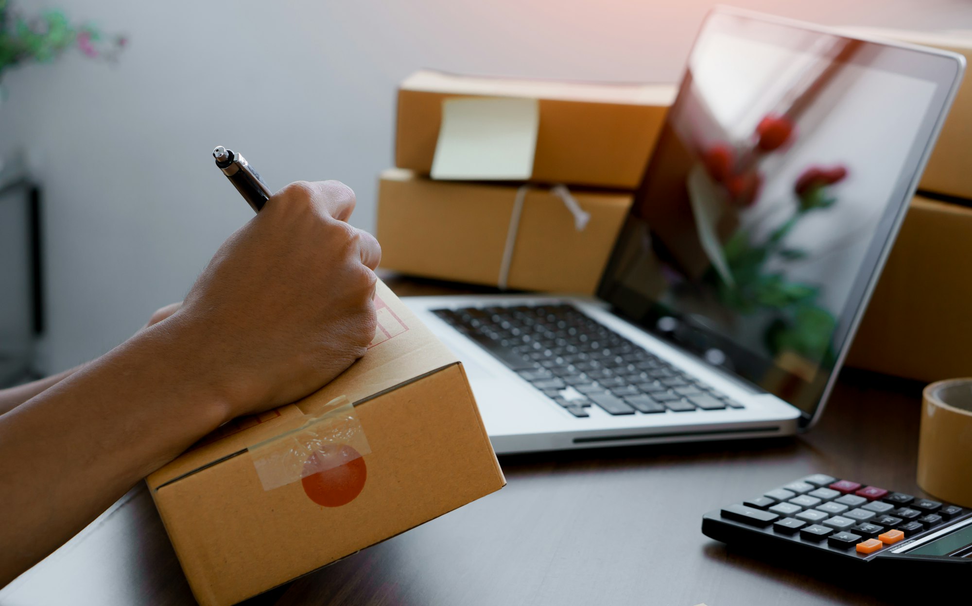 Shipping shopping online ,Young man writing address on cardboard box at workplace.work at home. Shipping shopping online ,Young man writing address on cardboard box at workplace.work at home.