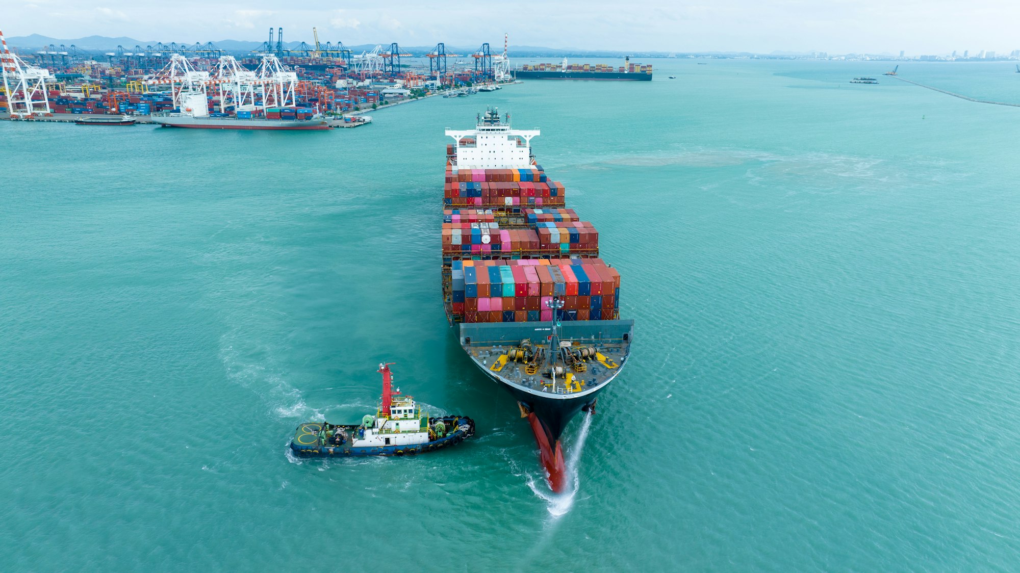 front view Cargo Container ship with contrail in the ocean ship carrying container and running